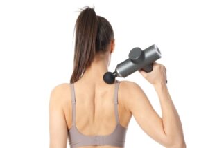 Image of a Muscle Massager Gun in use, highlighting its popularity among fitness enthusiasts despite growing concerns about its effectiveness.